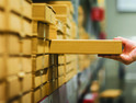 Hand pulling a box off of a warehouse shelf full of boxes