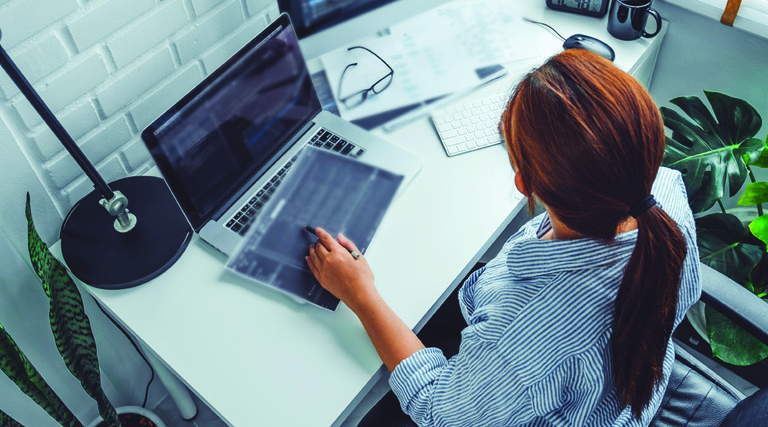 overhead shot of woman with multiple computer monitors