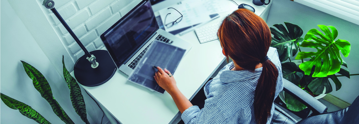 overhead shot of woman with multiple computer monitors