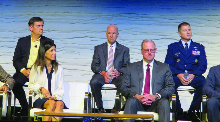 Two rows of people, three men at the top, one man, one woman and two men at the bottom, all in business wear