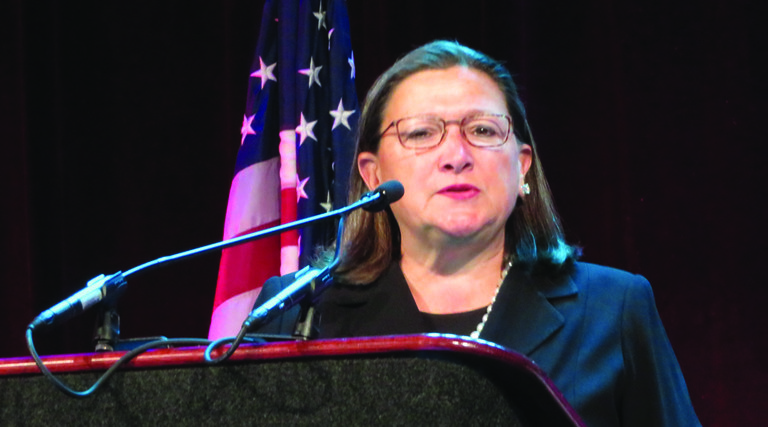 Woman with glasses behind podium