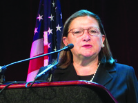 Woman with glasses behind podium