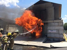 Firefighters hosing down a small house on fire