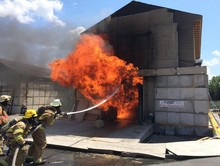 Firefighters hosing down a small house on fire