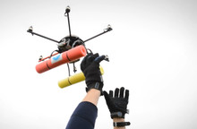 hands lifting a drone into the air